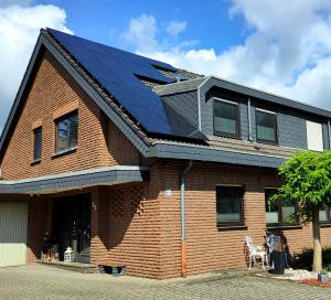 uma casa com painéis solares no telhado em Auszeit im Grünen - Ferienwohnung in Hünxe em Hünxe