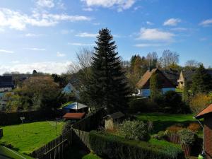 a tree in a yard next to a fence at Auszeit im Grünen - Ferienwohnung in Hünxe in Hünxe