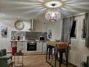 cocina con mesa y reloj en el techo en Superbe studio cocooning au cœur de la Sologne., en Nouan-le-Fuzelier