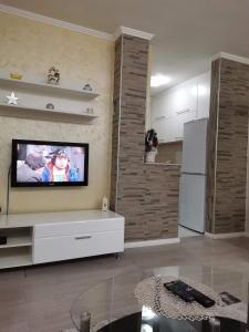 ein Wohnzimmer mit einem Flachbildfernseher an der Wand in der Unterkunft Kole Apartman in Pale