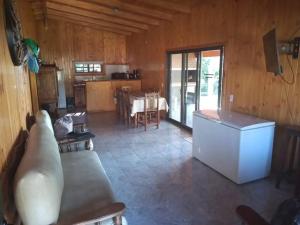 a living room with a couch and a kitchen with a table at Cabaña panorámica sobre el PARANÁ y Pesca in Itá Ibaté