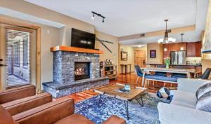 a living room with a couch and a fireplace at Luxurious Rundle Cliffs Lodge in Spring Creek in Canmore