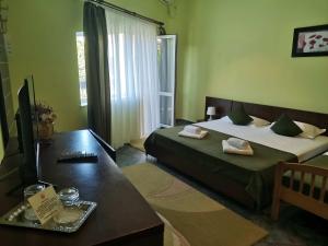 1 dormitorio con 2 camas, mesa y TV en Vila Casa Esy, en Eforie Nord