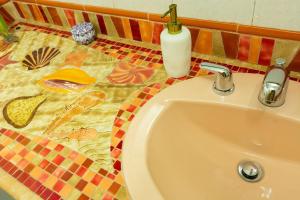 a bathroom with a sink and a tile floor at Hotel Casa Esencia in Medellín