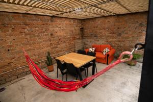 a hammock in a patio with a table and chairs at Hotel Casa Esencia in Medellín