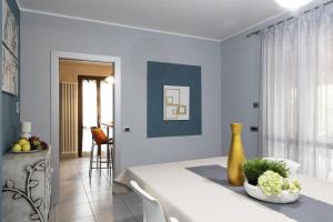 a white bedroom with a table and a yellow vase at ALBA-ASTI-LANGHE Villa con vigna, patio e piscina in Vinchio