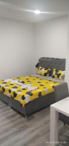 een slaapkamer met een bed met een gele en zwarte deken bij Mars in Banja Luka