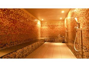 bagno con parete in mattoni e doccia di The QUBE Hotel Chiba - Vacation STAY 02227v a Chiba