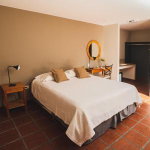 A bed or beds in a room at El Arribo Hotel