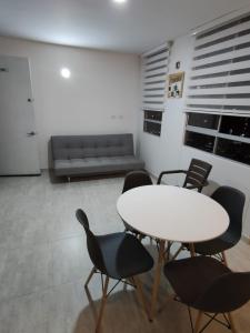 Habitación con mesa, sillas y sofá en Encantador y acogedor apto amoblado villavicencio, en Villavicencio