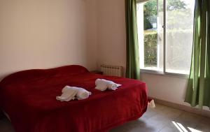 dos cabezas de animales en una cama roja en un dormitorio en La Canquelera, en Sierra de la Ventana