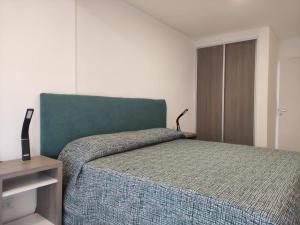 een slaapkamer met een bed met een groen hoofdeinde bij RCT Club Vacacional & SPA in Chapadmalal