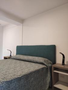 1 dormitorio con 1 cama con cabecero azul en RCT Club Vacacional & SPA en Chapadmalal