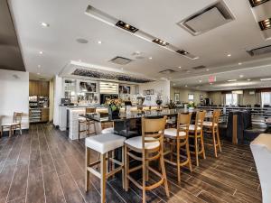 a restaurant with a bar with wooden stools at Radisson Hotel Edmonton Airport in Leduc