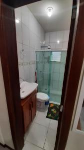 een badkamer met een toilet, een wastafel en een douche bij Pousada Pegadas na Areia in Palhoça