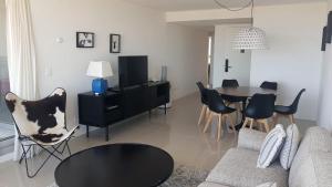 a living room with a couch and a table and chairs at Apartamento con terraza propia - Se permite mascota - Edificio Lumiere in Punta del Este