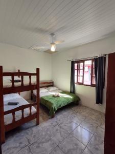 1 dormitorio con 2 literas y ventana en Ferrugem Flat, en Garopaba