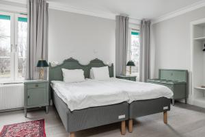 um quarto com uma cama grande e 2 janelas em Söderköpings Brunn em Söderköping