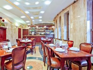un restaurante con mesas y sillas de madera y un bar en Pensjonat Klimek en Muszyna