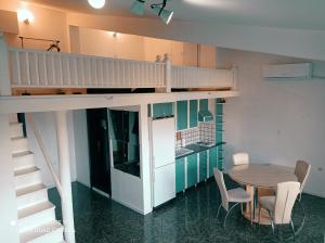a loft bed in a room with a table and chairs at OHRID LOFT : The Den in Ohrid