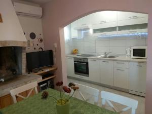 a kitchen with a table with a vase with flowers on it at Holiday home Ivo in Prigradica +38 photos