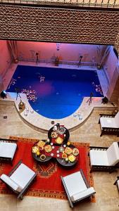 una piscina con una mesa con comida delante en Riad Zyna, en Meknès