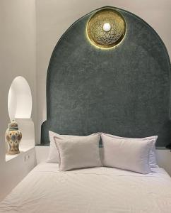 um quarto com uma cama com uma parede verde em Riad Zyna em Meknès