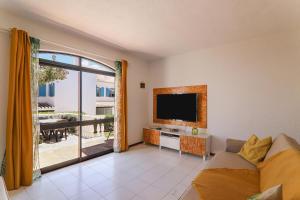 een woonkamer met een flatscreen-tv en een bank bij Vila Mourisca in Porches