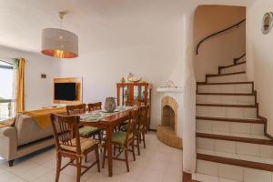 een woonkamer met een eettafel en een open haard bij Vila Mourisca in Porches