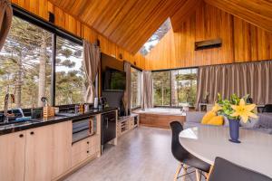 a kitchen with a table and chairs and windows at Morada Reino Encantado in São Joaquim