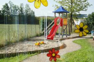 a playground with a red slide in a sandbox at EuroHotel Günzburg in Günzburg