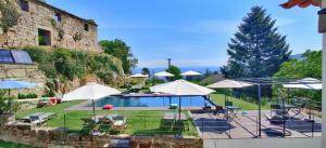 a patio with tables and umbrellas and a pool at Paço de Vilharigues in Vouzela