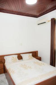 1 dormitorio con 1 cama grande y cabecero de madera en Villa luxueuse - Odza - Yaoundé, en Yaoundé