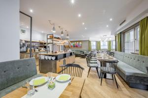 ein Restaurant mit Tischen und Stühlen und einer Küche in der Unterkunft Arlen Lodge Hotel-Garni inkl Premium Sommerkarte in Sankt Anton am Arlberg
