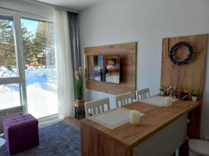 una sala da pranzo con tavolo e una grande finestra di Studio Lola Jezero a Divčibare
