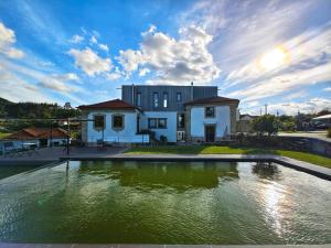 a large pool of water in front of a building at Paço de Vilharigues in Vouzela