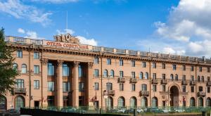 un grand bâtiment avec un panneau en haut dans l'établissement Legendary Hotel Sovietsky, à Moscou