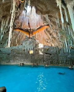 uma caverna com uma águia na parede e pessoas na água em Terra Parque Eco Resort em Presidente Prudente