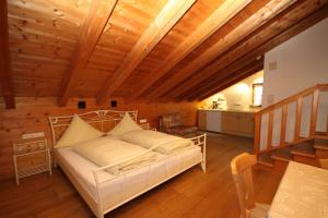 ein Schlafzimmer mit einem weißen Bett und einer Holzdecke in der Unterkunft Ferienwohnungen Dananic in Anger