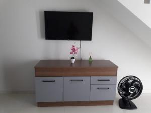 a room with a tv on a white wall at Casa em Costazul - Rio das Ostras in Rio das Ostras