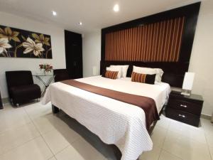 een slaapkamer met een groot bed en een stoel bij Monterrico Hotel Perú in Lima