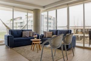 sala de estar con sofá azul y sillas en Martinique Cartagena, Beautiful 1 & 2 Bedroom Apartments, en Cartagena de Indias