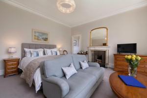 a bedroom with a bed and a couch and a television at Lys-Na-Greyne Country House in Aboyne