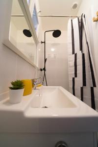 y baño con lavabo blanco y espejo. en AppartUnique - Chez Majorelle, en Vichy