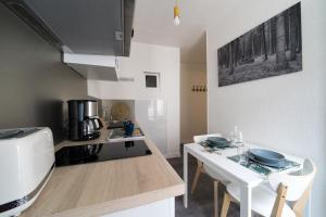 a kitchen with a table and a stove top oven at AppartUnique - Chez Majorelle in Vichy