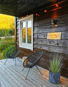 duas cadeiras sentadas num deque em frente a uma cabina em Bjørkelia Lodge em Vassenden