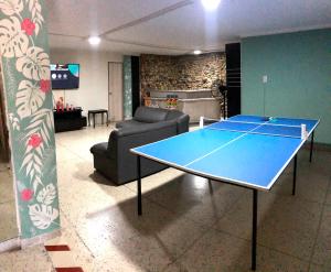 mesa de ping pong en la sala de estar con sofá en La Quinta Bacana La Campiña en Barranquilla