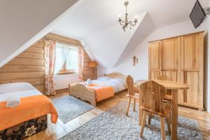 a bedroom with two beds and a table at Góralski Dworek in Czarna Góra