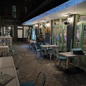 un restaurante con mesas y sillas y un árbol de Navidad en Centar Novi Sad-Apartman No 3 PARKING ON REQUEST, en Novi Sad