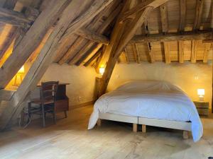 ein Schlafzimmer mit einem Bett und einem Stuhl im Dachgeschoss in der Unterkunft La Ferme de Châtenoy - Le Mouton Noir in Châtenoy